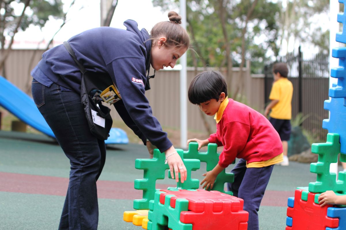A teacher and student interact within the playground at Western Sydney School